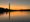 Soft colors in the sky and reflected in the water of the Tidal Basin, mainly orange hues that fade into blue-gray at the top of the sky and photo