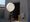 Man walking out of a building holding a weather balloon.