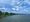 Mix of puffy clouds and blue skies over the tree-lined Potomac River.