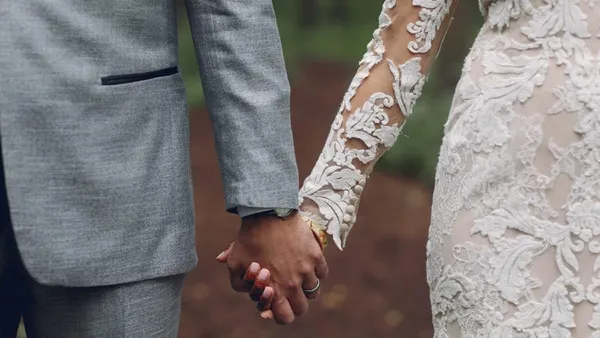 A picture of a married couple holding hands.