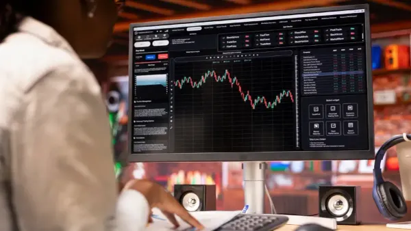 A picture of a woman watching a stock ticker symbol. 