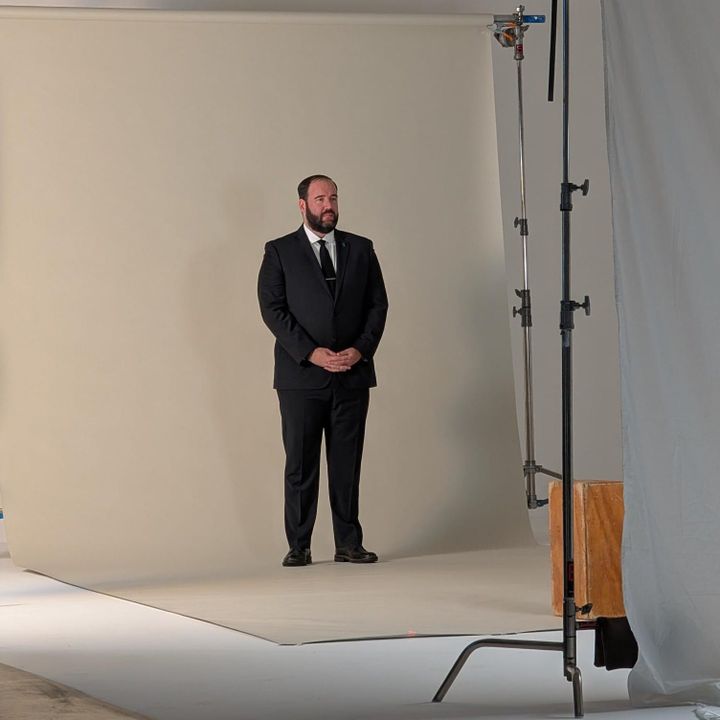 A photo of Philip Fields in wearing a suit standing in a studio.
