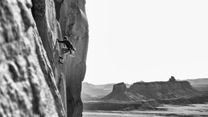 A rock climber climbing cracked rock