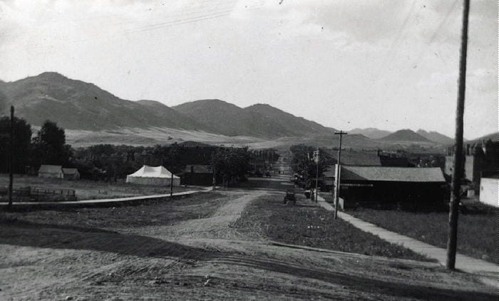 Black and white photo of Washington Avenue before it was paved A large tent is set up in a vacant lot at approximately 13th and Washington.