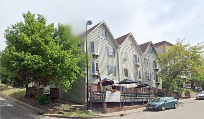 Three tall, narrow rowhouse-type buildings with peaked roofs and 3-1/2 stories