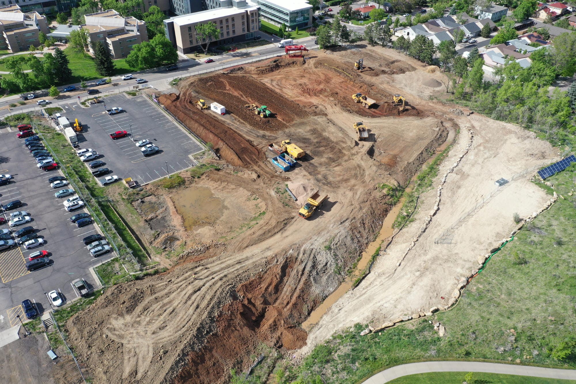 bulldozers grading the site, exposing reddish soil