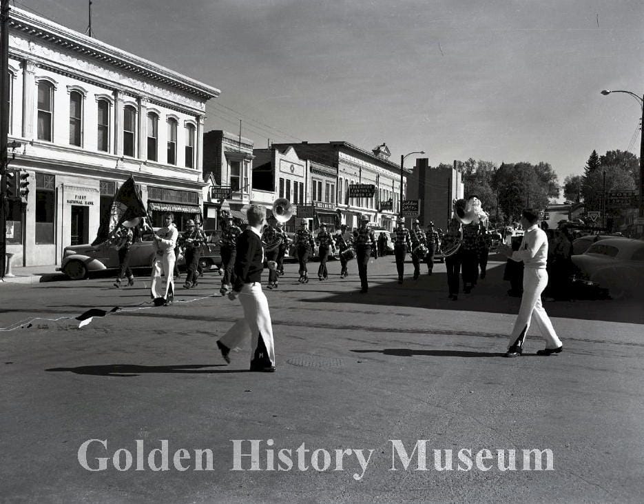 First National Bank (southeast corner of 12th and Washington) with a marching band in front