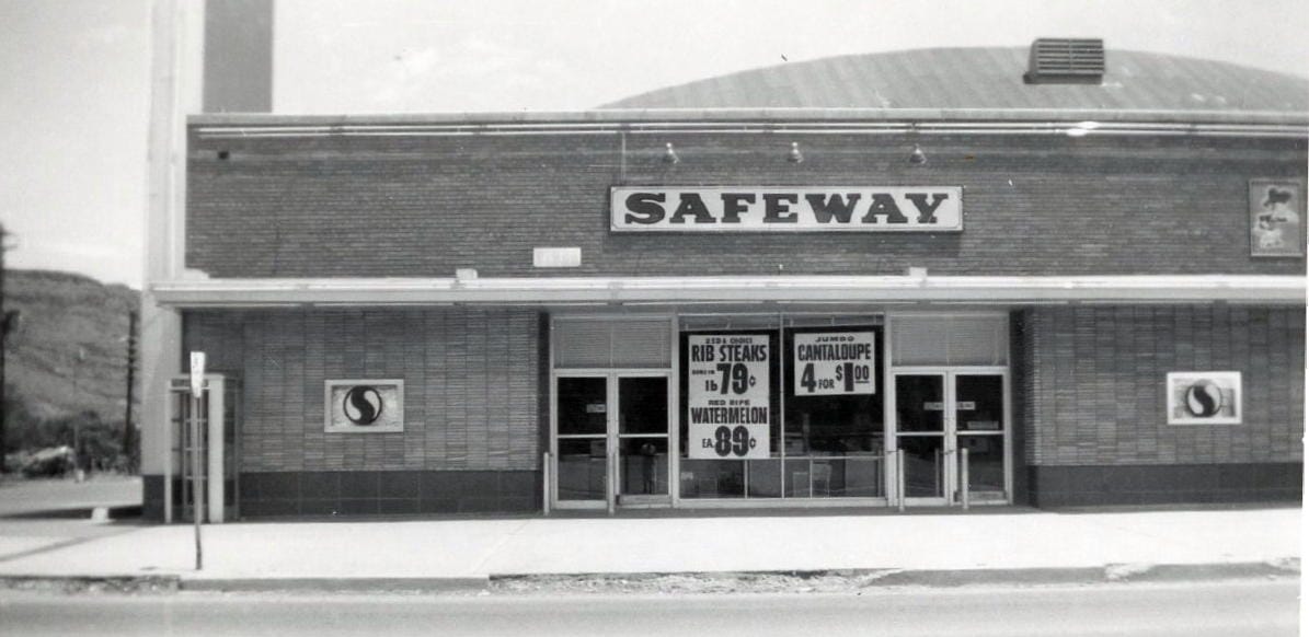 Brick Safeway grocery store, with posters advertising steaks for 79 cents/pound and cantaloupe 4 for $1