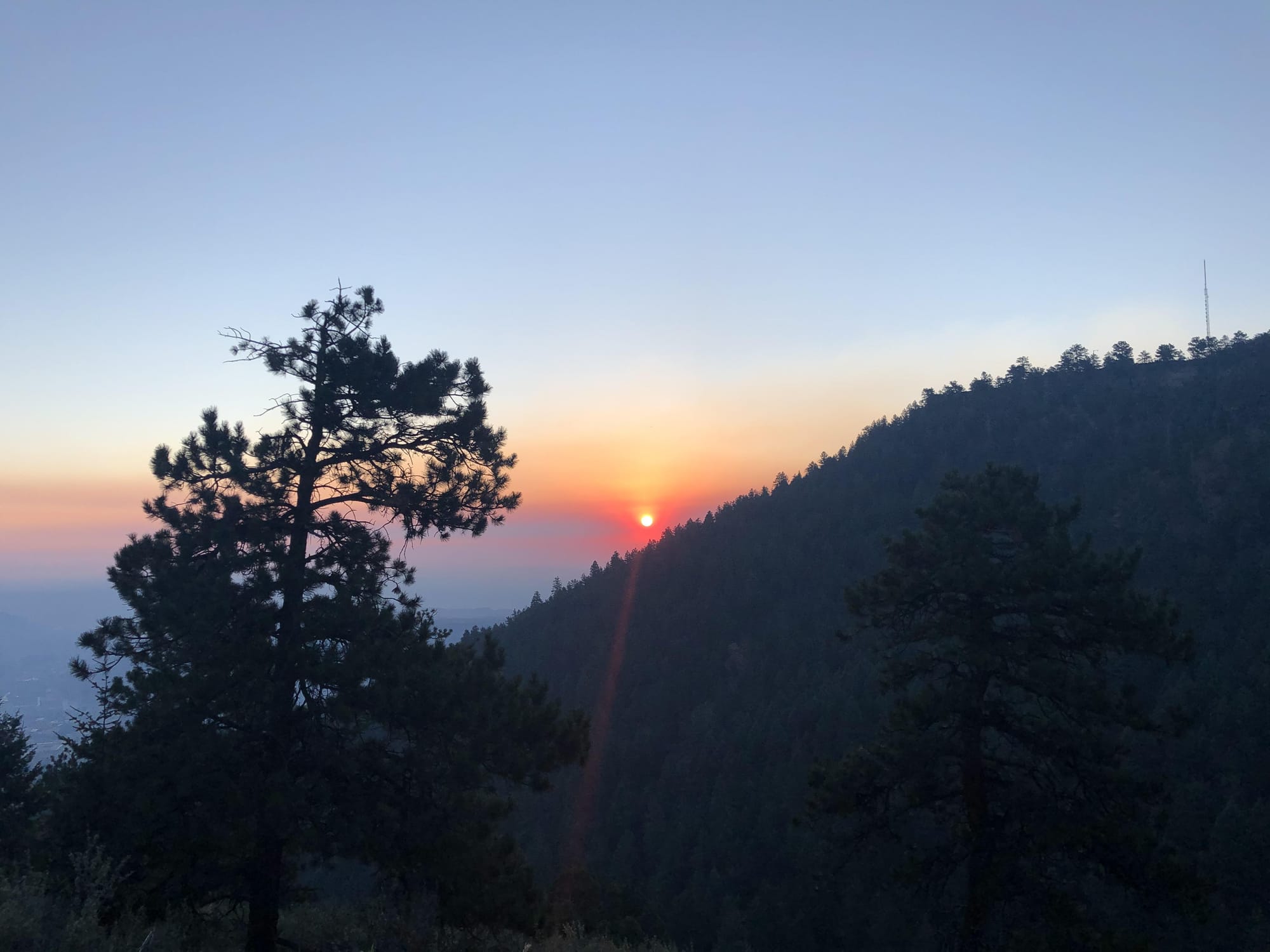 orange sun peeking over the pine-covered shoulder of Lookout Mountain