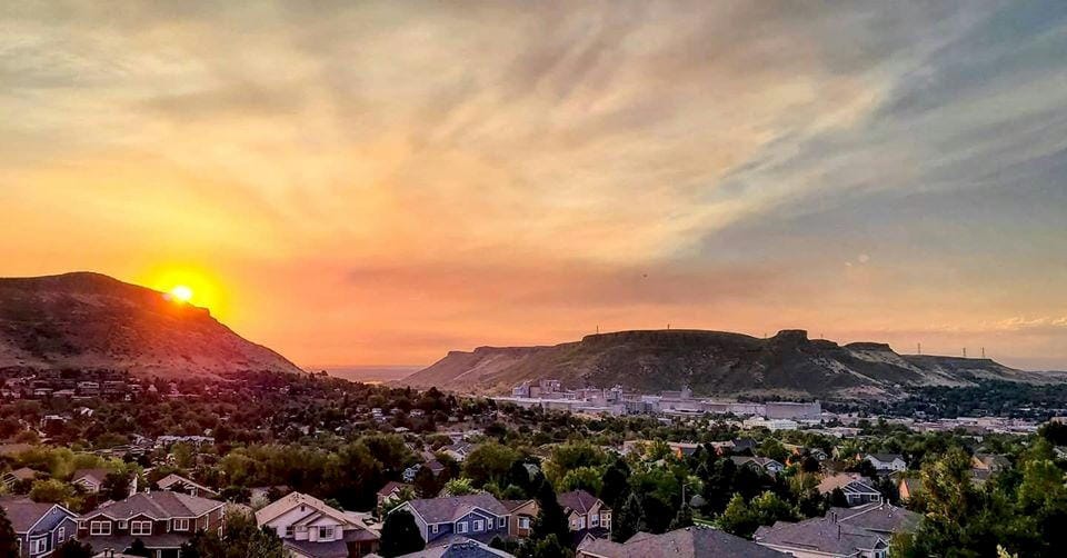 view of North & South Table Mountain with the sun rising between in an orange sky