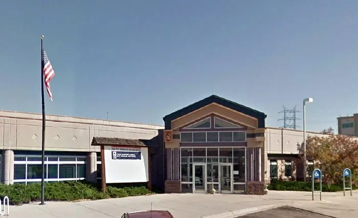 large one story building with American flag on tall flagpole in front