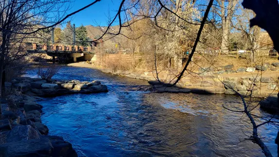 Clear Creek in early spring - trees bare, grass brown, water a deep blue