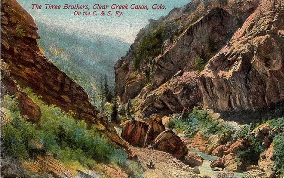 Hand-tinted postcard shows a narrow canyon with red rock walls.  Title labels it "The Three Brothers"