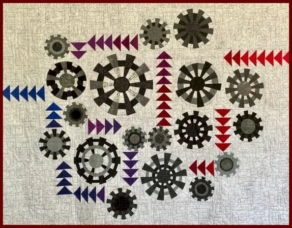 quilt with cream-colored background withaliques of arrows and propellers