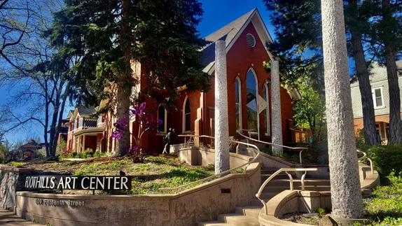 old red brick church with a sign in front saying "Foothills Art Center"