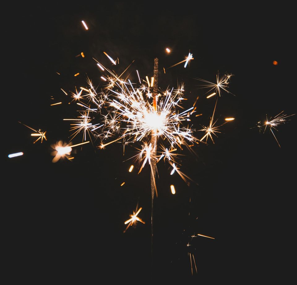 A lit sparkler in front of a black background
