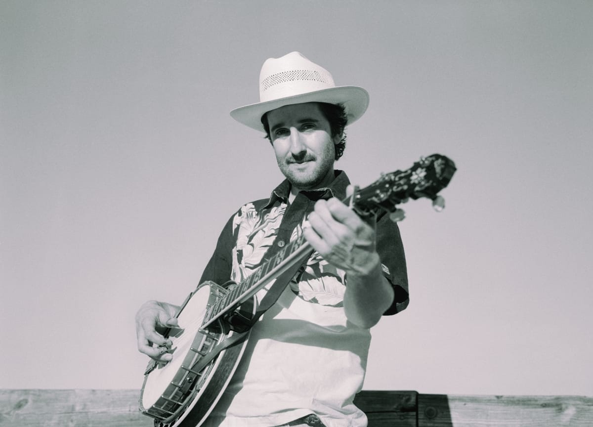 A black-and-white photo Max Wareham playing banjo. Photo by Ross Kiah.