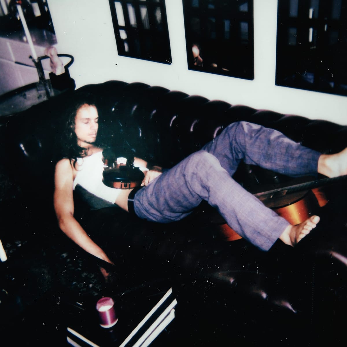 Louis Gardner asleep on a couch with a violin on his stomach.