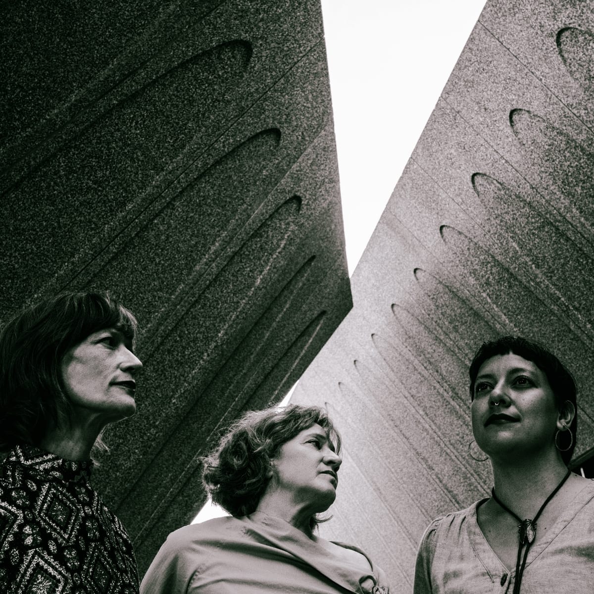 Sarah Morrison, Holly Tavel, Beatriz Ramirez-Belt of Lost Noises Office from below against angular concrete, black and white. Photo by Jim Leatherman.