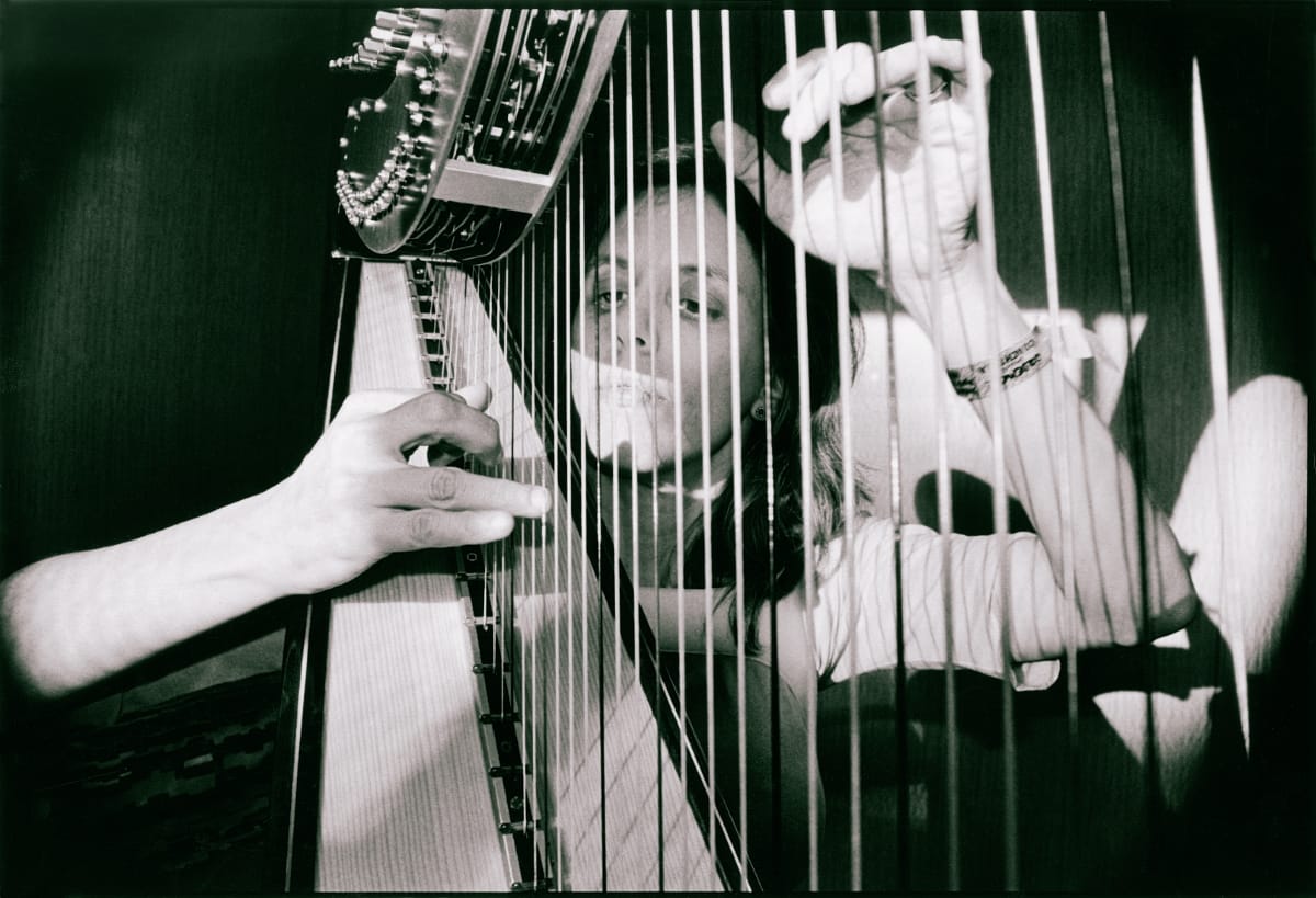 Zeena Parkins plays modified electric harp with visible pickups and electronics, black and white photograph.
