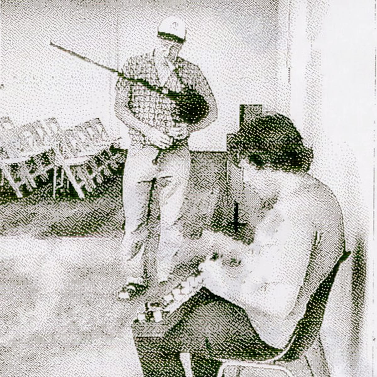 David Watson stands playing Highland bagpipes while Bill Nace sits beside him tuning a taishōgoto, in a grainy, high-contrast halftone photograph.