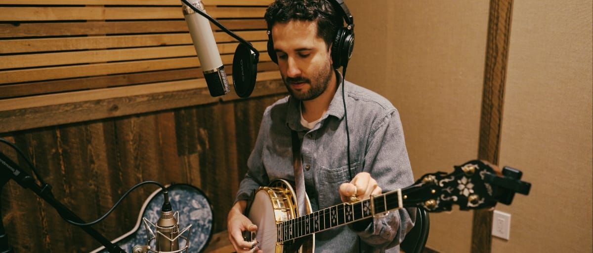 Max Wareham in the recording studio holding a banjo. Photo by Kaitlyn Raitz.