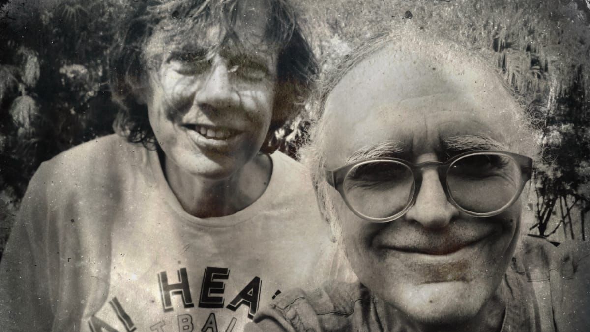 Thurston Moore and Bonner Kramer smile in a tintype-style black-and-white outdoor photo; Moore in a Heat basketball shirt, Kramer in round glasses, foliage behind them.