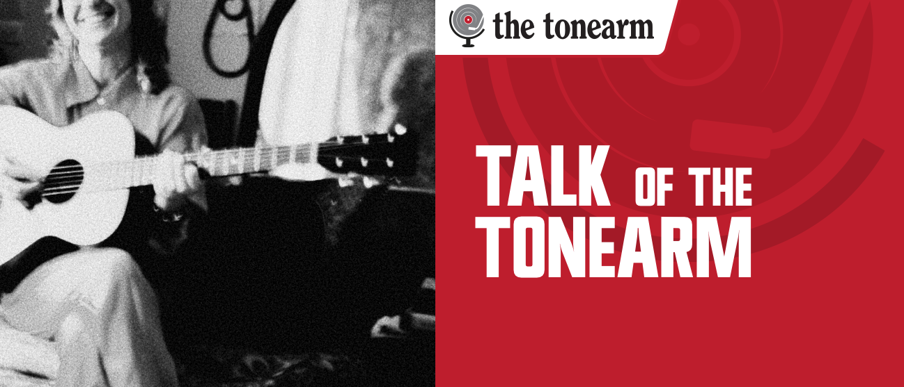Sophie Wellington smiles while playing acoustic guitar in a grainy black-and-white photo, beside a red panel reading TALK OF THE TONEARM with The Tonearm logo.