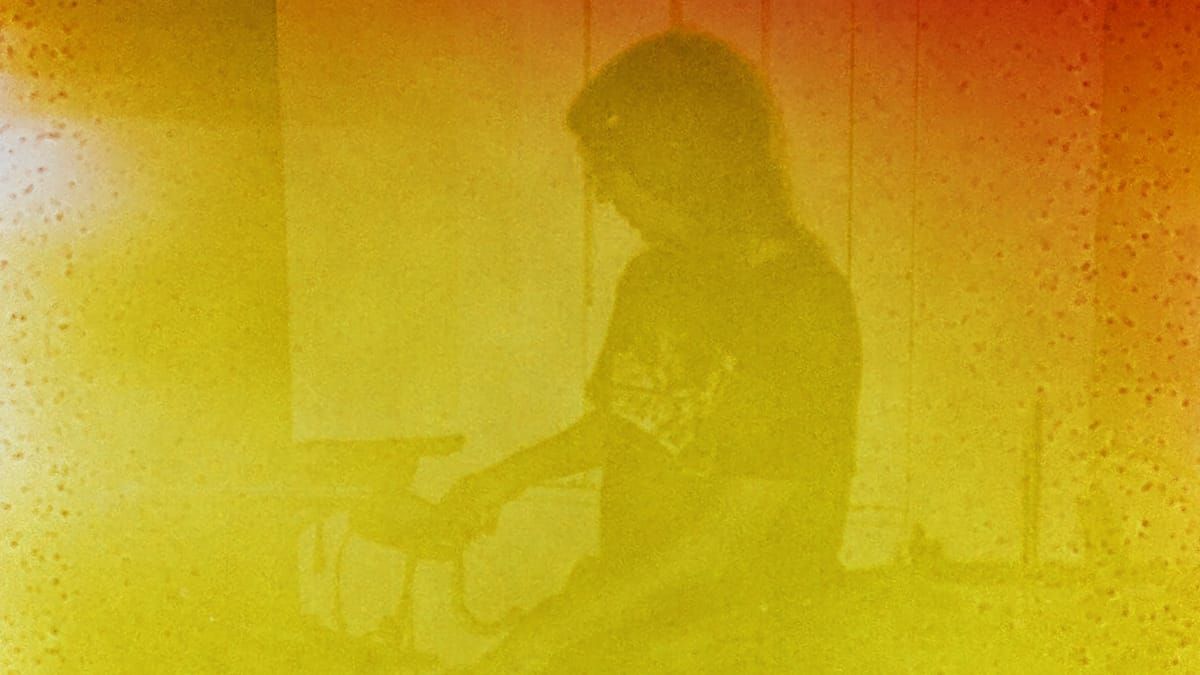 Fling ii: a drummer in silhouette at the kit, arm reaching toward a cymbal, the whole frame washed in grainy yellow and orange.