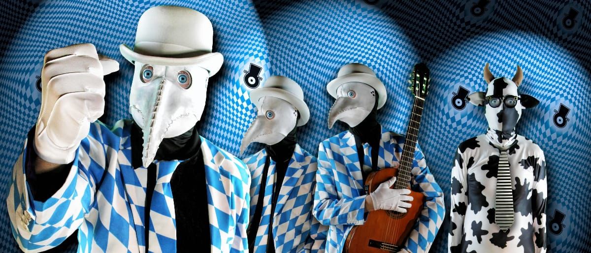 The Residents in a row: three in white beaked masks, bowlers, and blue-and-white diamond suits, one holding an acoustic guitar, beside a figure in a horned cow-print suit and striped tie.