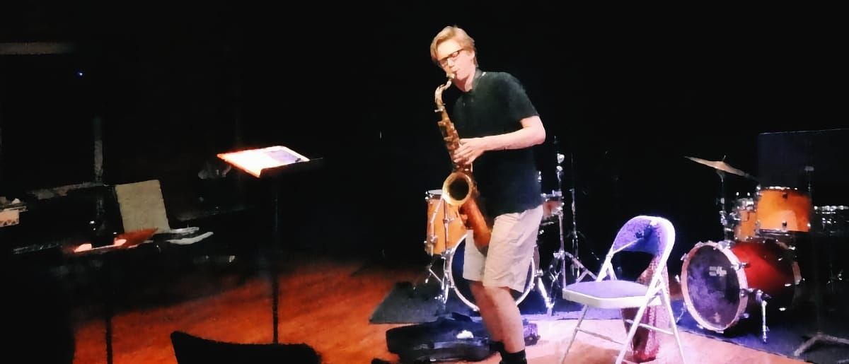 Harrison Argatoff playing saxophone alone in a room.