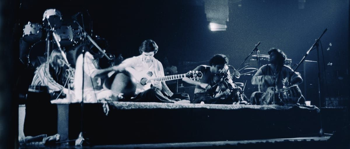 John McLaughlin and Shakti in 1976. Photo by Ali-Khan via Wikimedia Commons.