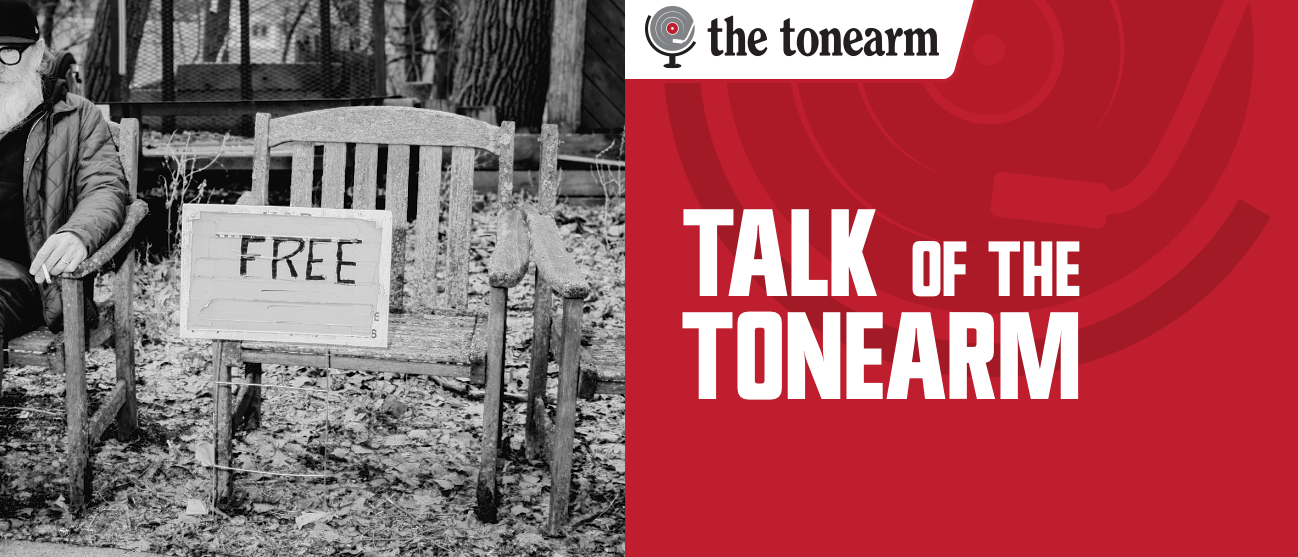 Talk Of The Tonearm masthead. A black-and-white photo of a weathered wooden bench on fallen leaves, a hand-lettered FREE sign propped against it, beside a red panel with The Tonearm logo.