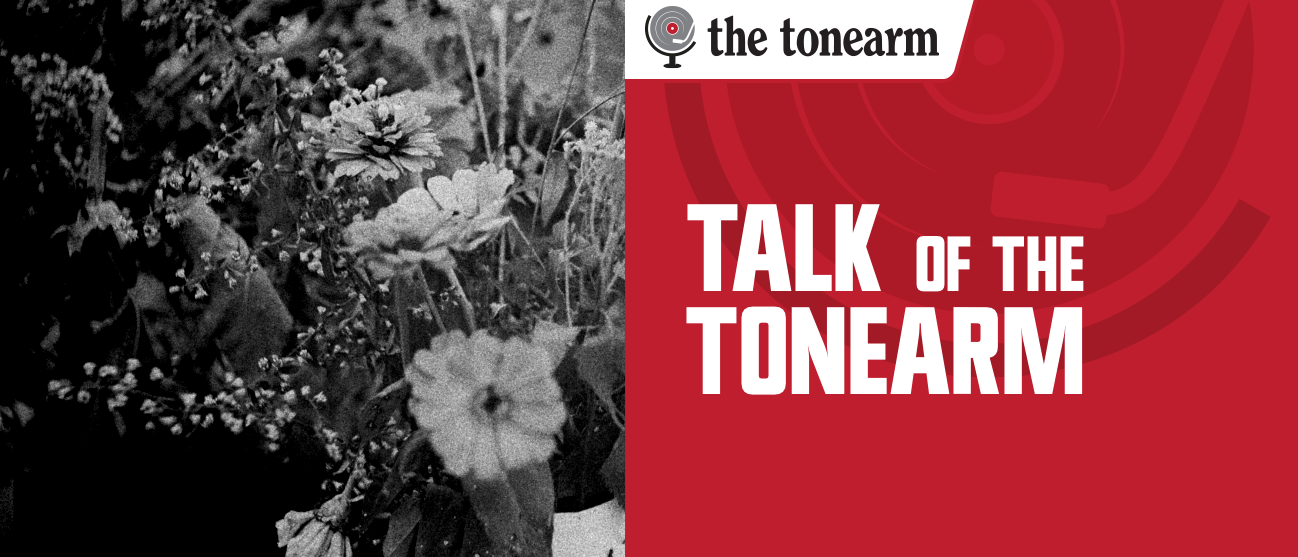 Grainy black-and-white photo of zinnias and wildflowers beside a red panel reading “Talk Of The Tonearm,” topped by The Tonearm logo.