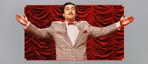 Robert De Niro as Rupert Pupkin stands arms outstretched in a sequined jacket and bow tie before red stage curtains, in a promotional image from The King of Comedy.