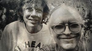 Thurston Moore and Bonner Kramer smile in a tintype-style black-and-white outdoor photo; Moore in a Heat basketball shirt, Kramer in round glasses, foliage behind them.
