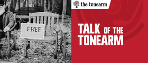 Talk Of The Tonearm masthead. A black-and-white photo of a weathered wooden bench on fallen leaves, a hand-lettered FREE sign propped against it, beside a red panel with The Tonearm logo.
