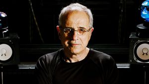 Bob Ezrin faces the camera in a dark studio, lit from the side, with a studio monitor on either side of him.