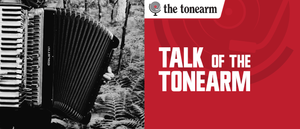 A black-and-white Giulietti accordion stands among ferns in woodland, beside a red panel reading "TALK OF THE TONEARM" with the tonearm logo above it.