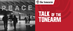 Silhouetted travelers cross an airport terminal past a mirrored wall spelling PEACE, beside a red panel reading TALK OF THE TONEARM with the tonearm logo above it.