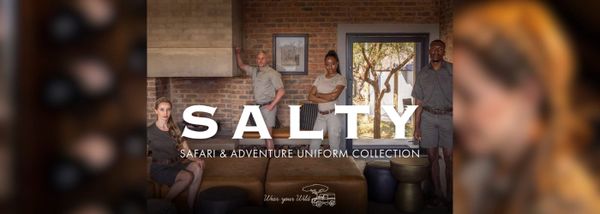 Four people pose in safari-themed uniforms in a rustic room with exposed brick walls. The text reads 'Salty Safari & Adventure Uniform Collection.' A relaxed, adventurous tone is conveyed.