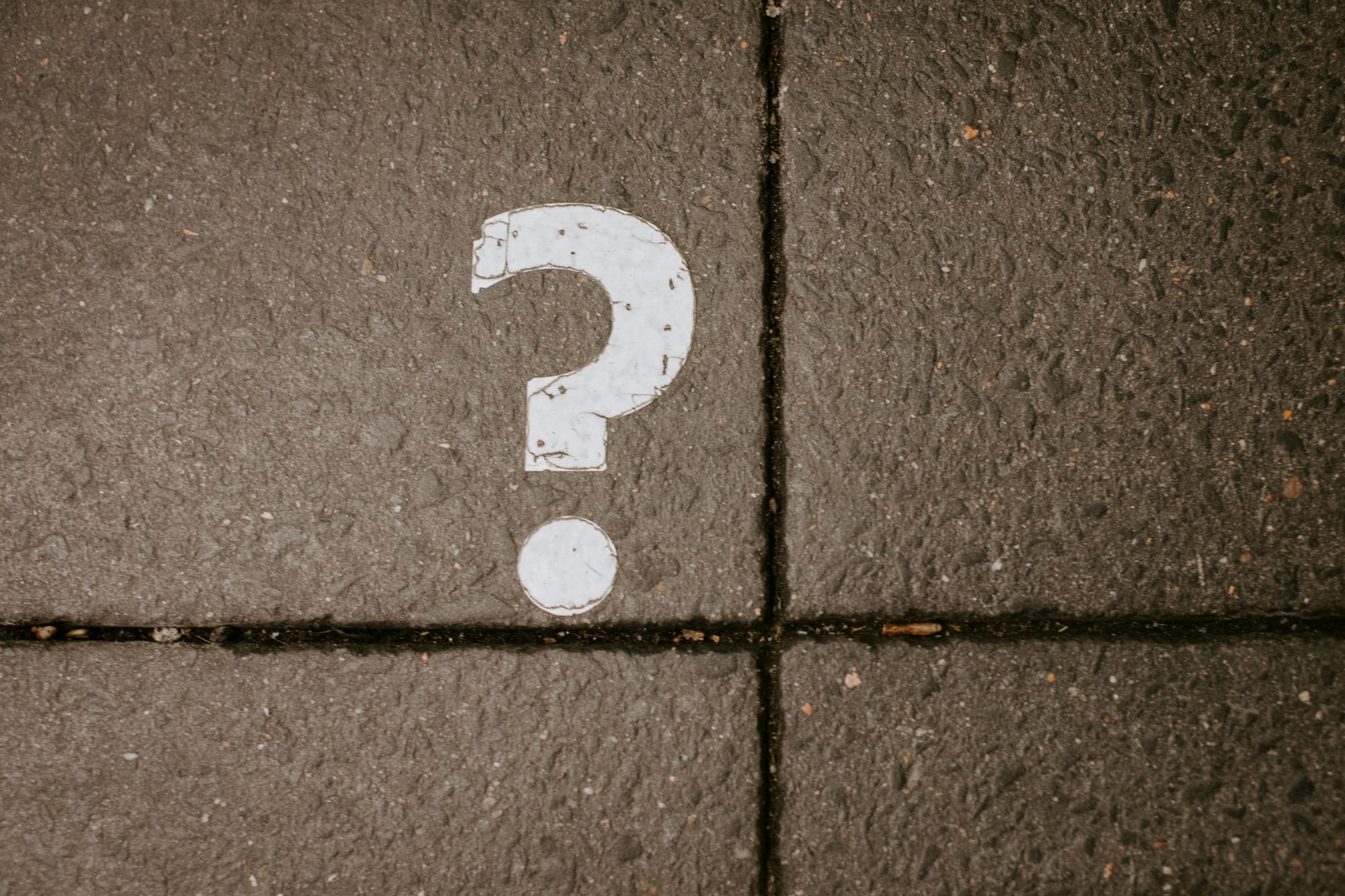 urban horse riders; white question mark on concrete pavement