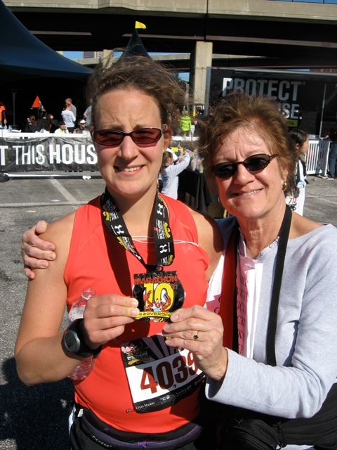 The author and her momther holding up a marathon medal, smiling