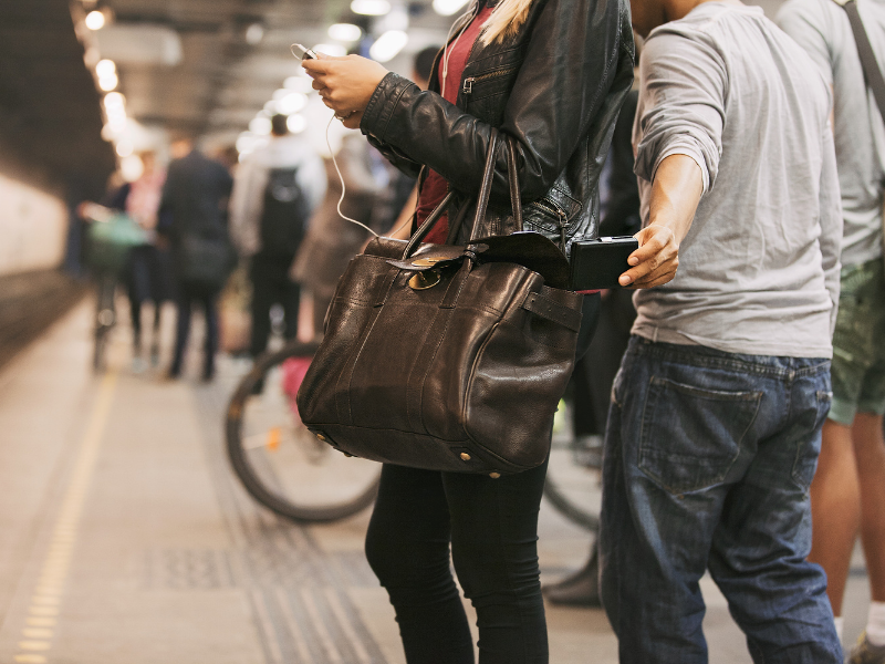 Person on a train platform, not paying attention and getting pickpocketed