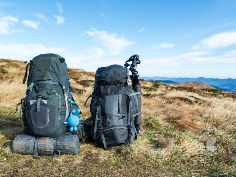 Two backpacks on a grassy hill