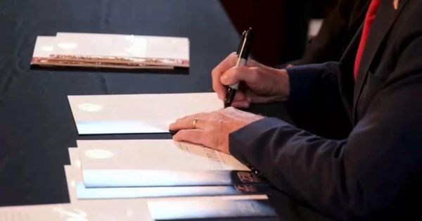 A ceremonial copy of the COINSOLATION trademark registration on the signing table, Washington D.C., 23 July 2026.