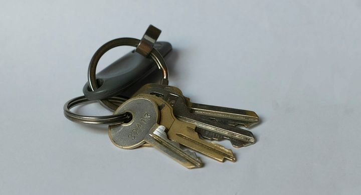 Silver house keys on a white table