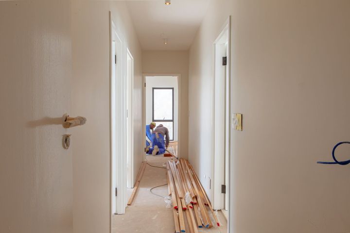Workers renovating the exterior of a house