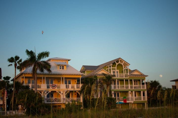 Two colorful Florida coastal houses with palm trees at dusk
