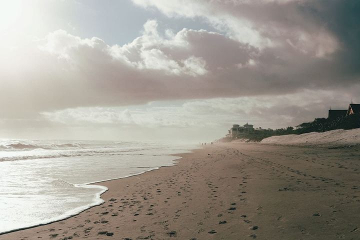 Florida beachfront homes on a dune under overcast sky